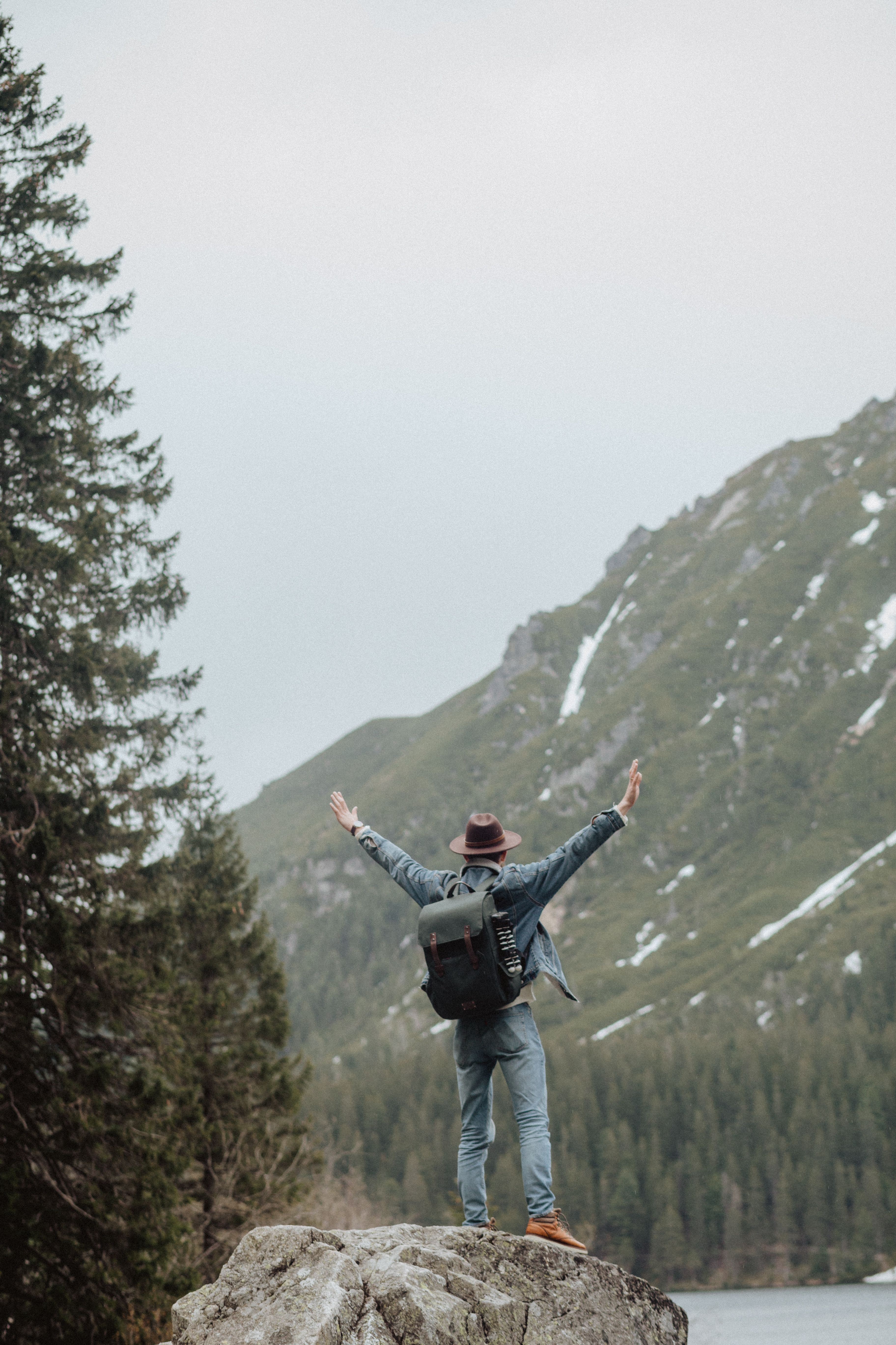 Man Wearing Blue Denim Jacket Standing on Rock Formation · Free Stock Photo