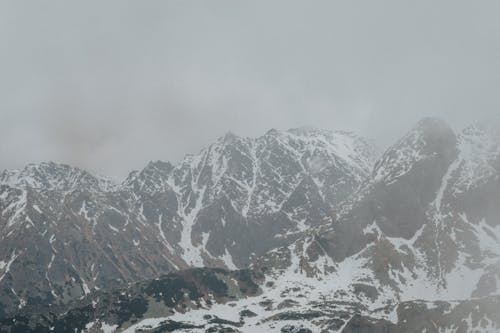 Snow Covered Mountains Under Gray Sky