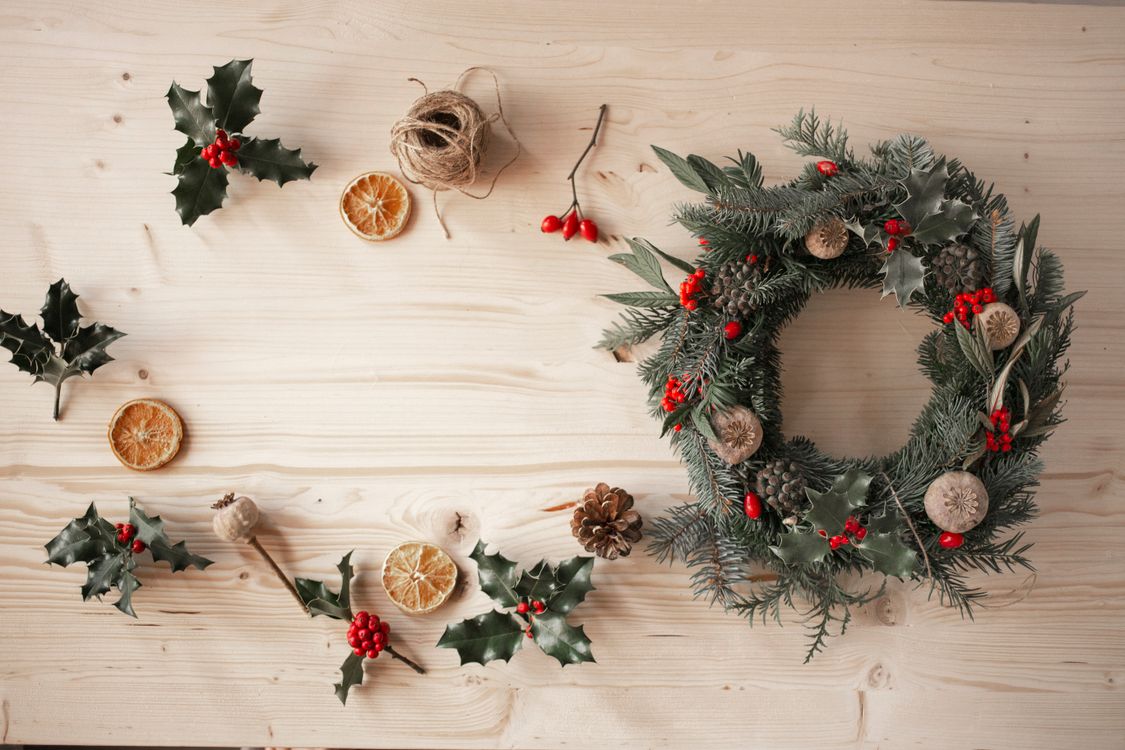 Christmas wreath supplies and decorations laid out on a wooden table