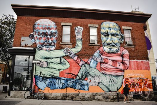 Colorful mural artwork on a brick wall in Montreal, showcasing bold street art.