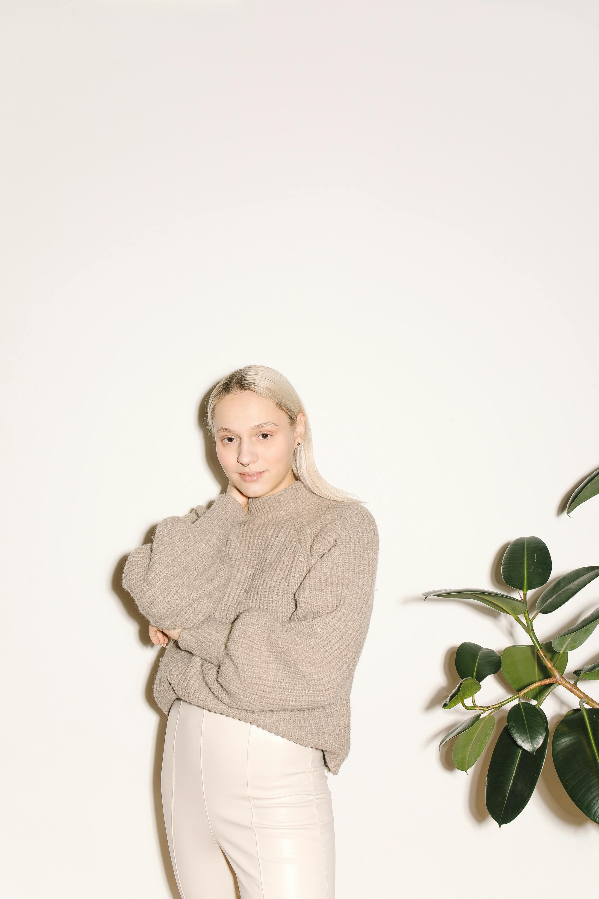 Girl in Gray Sweater Standing Beside Green Plant · Free Stock Photo