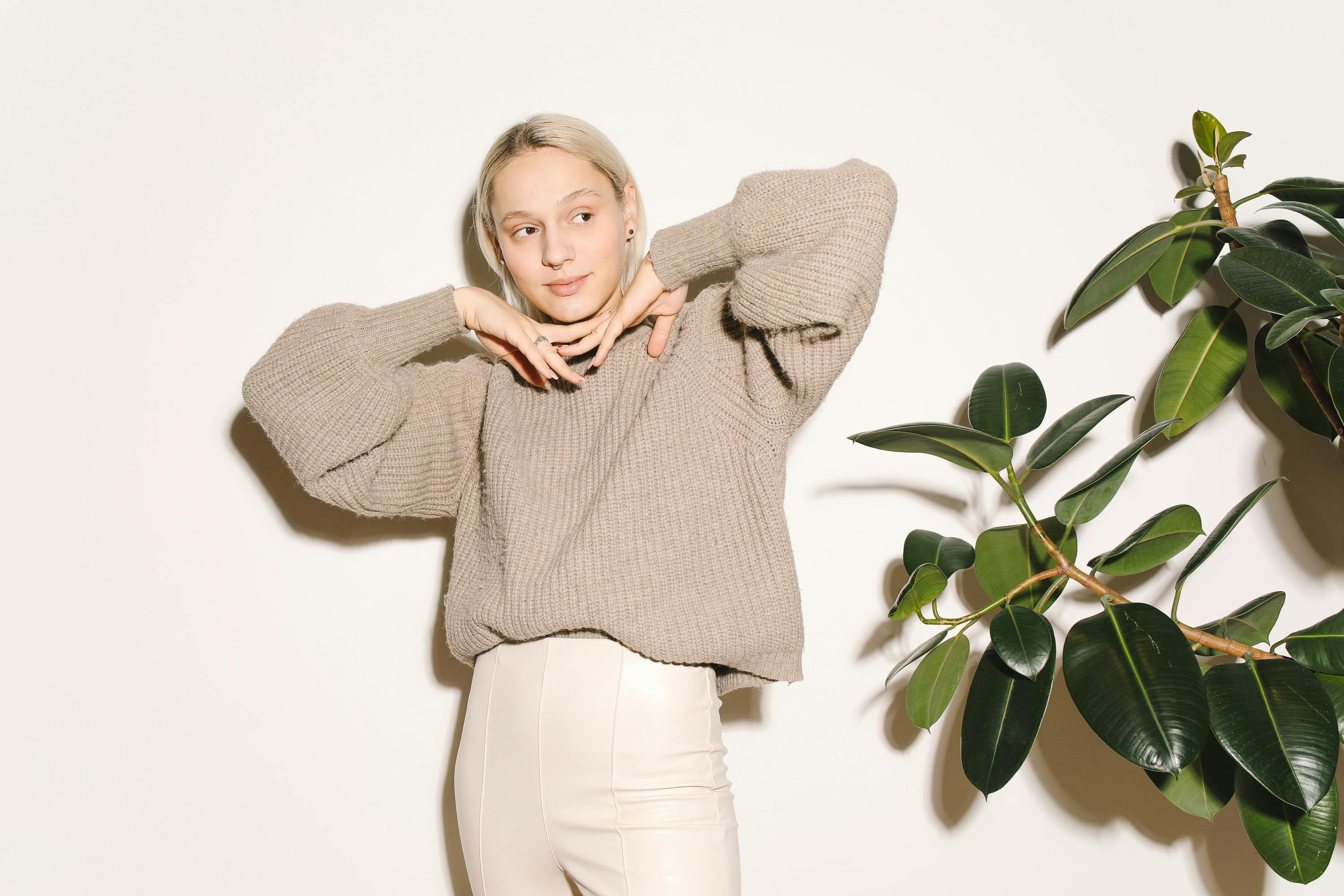 woman in gray sweater and white pants