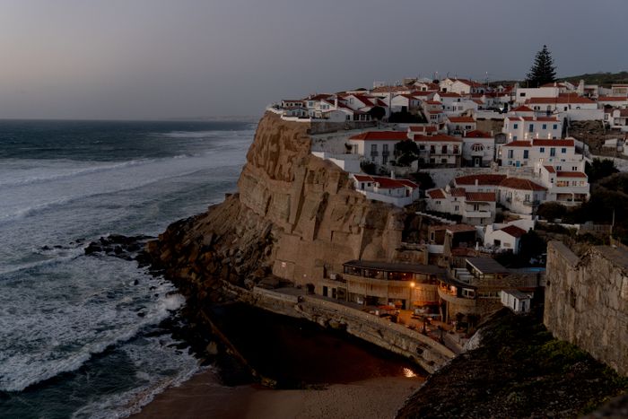 Whitewashed village on coastal cliffs above the surf — photo by alleksana on Pexels