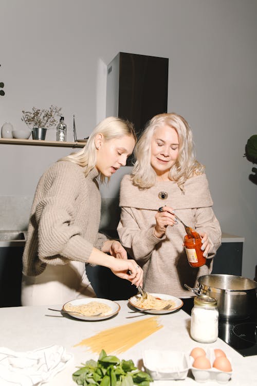 Free Mother And Daughter Preparing Spaghetti For Meal Stock Photo