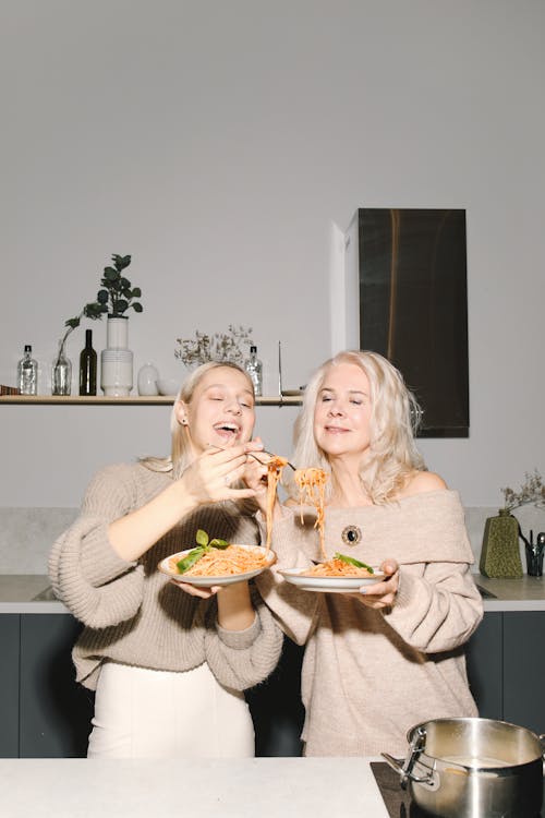 Mother And Daughter Smiling While Eating