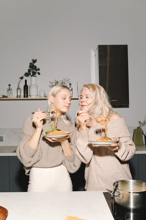 Mother And Daughter Enjoying Their Spaghetti