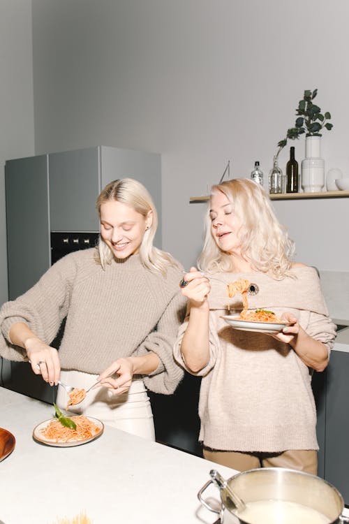 Free Mother And Daughter Eating Pasta Stock Photo