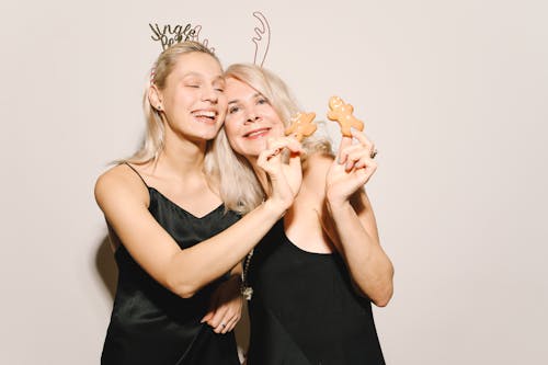 Smiling Mother And Daughter Holding Gingerbread Cookies 