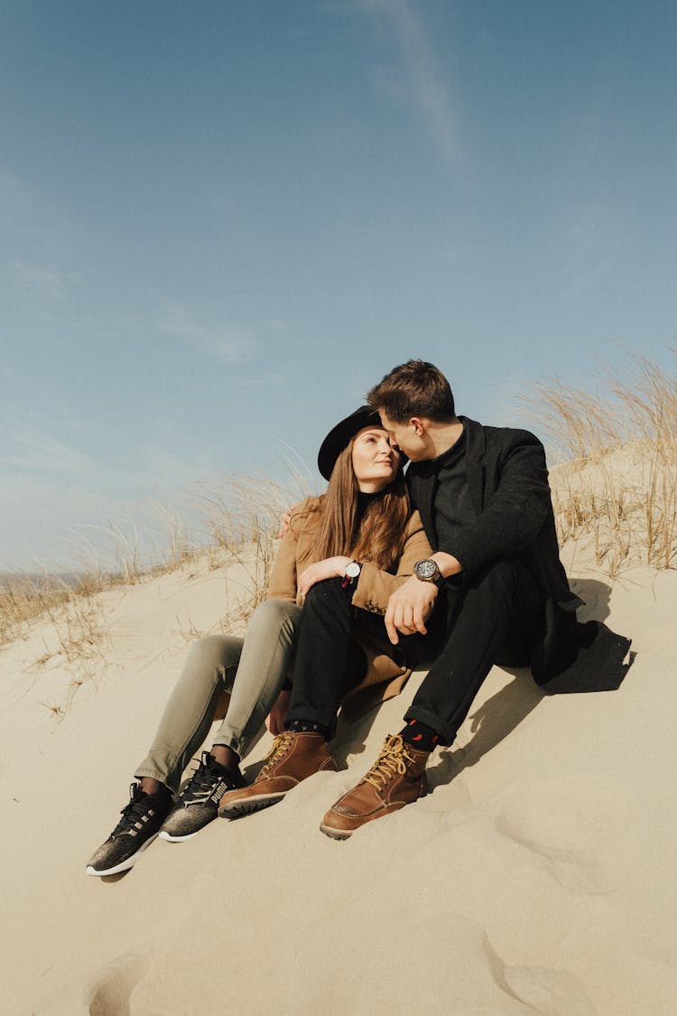 A Romantic Couple Sitting On The Sand