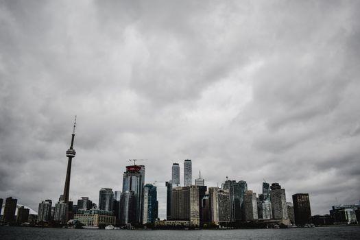 Dramatic view of Toronto's skyline featuring the CN Tower with a moody sky backdrop.