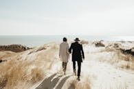 Man and Woman Walking on Brown Field