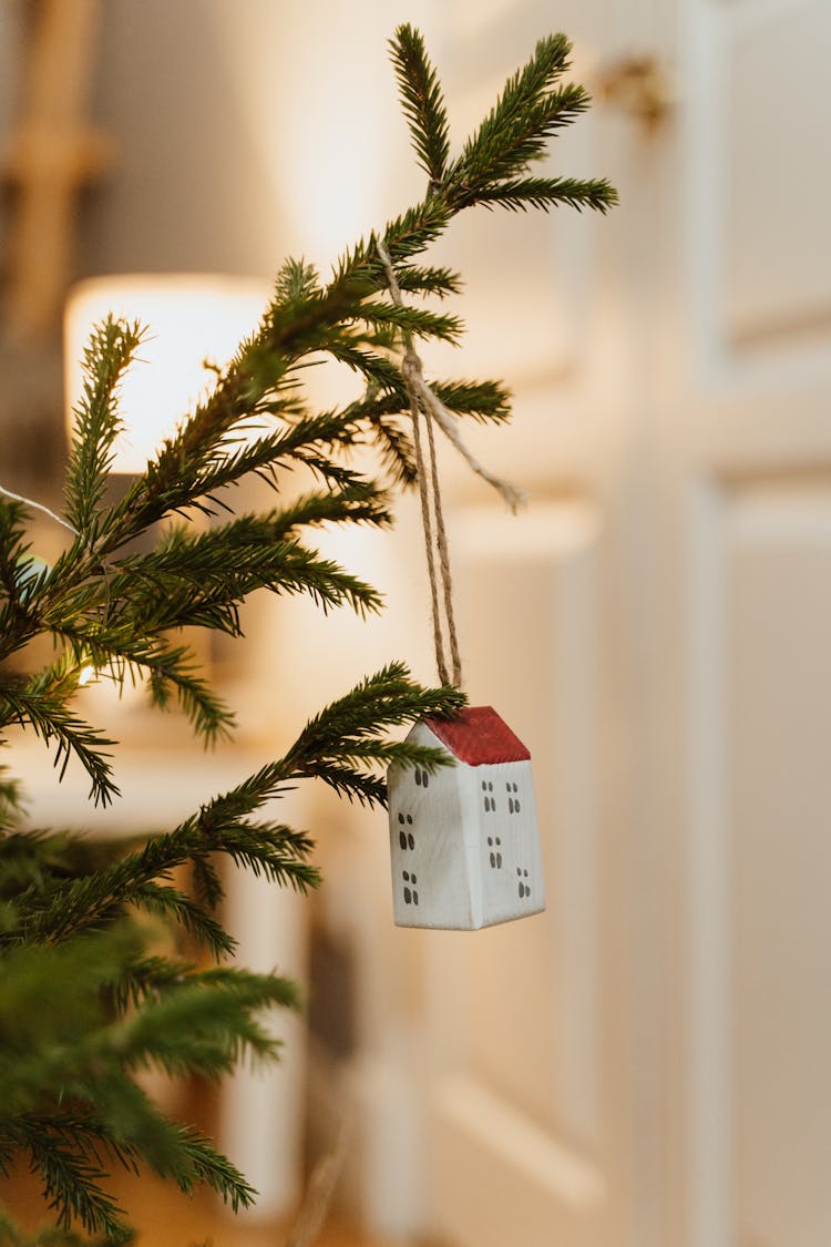 Red And White House Ornament Hanging On A Christmas Tree