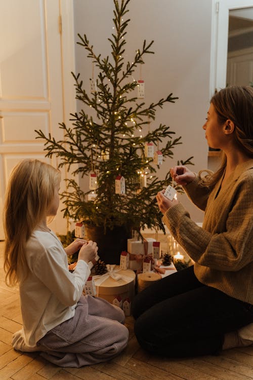 Woman and a Girl Decorating the Christmas Tree Together 