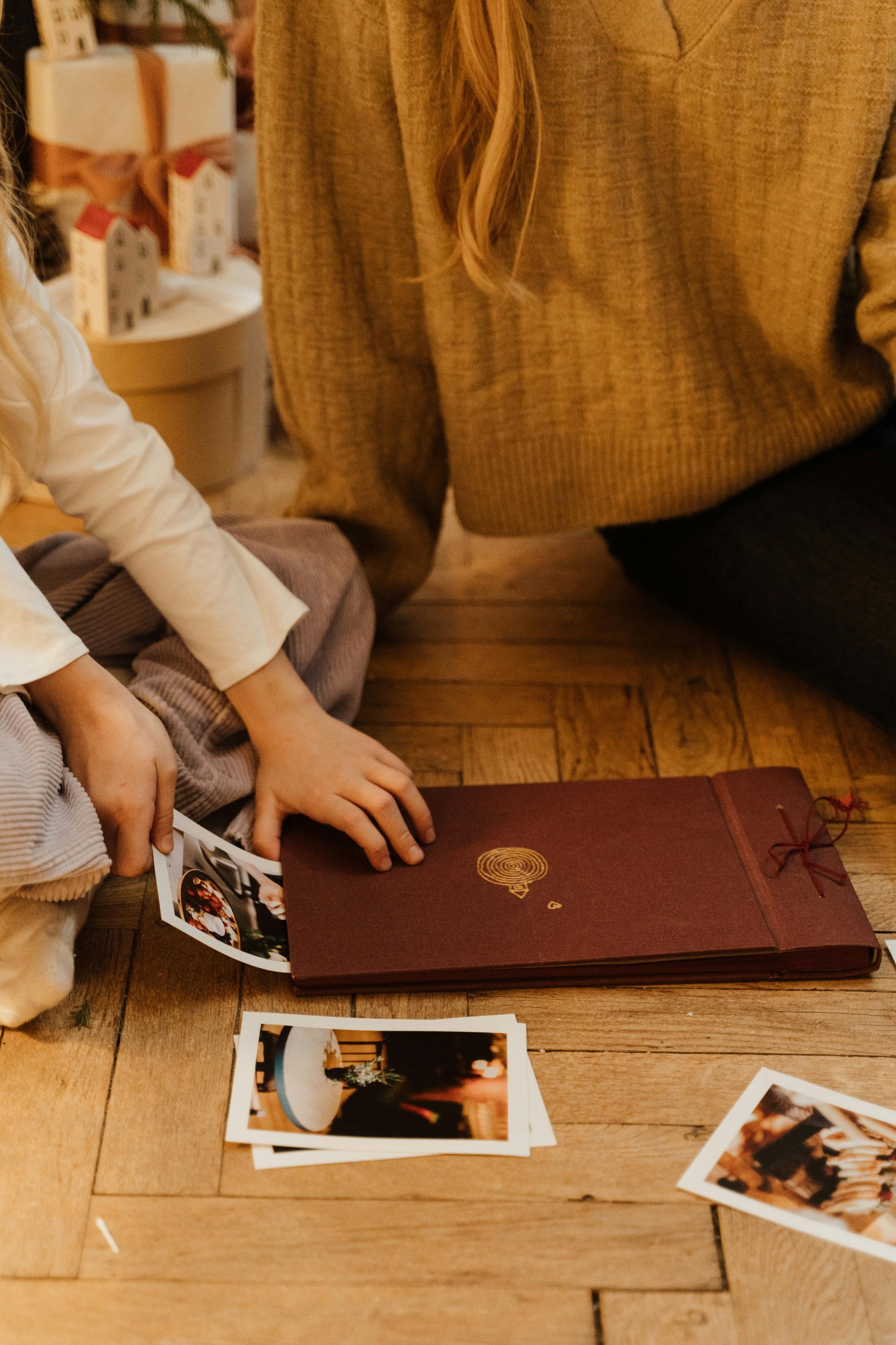 little girl putting photos into an album