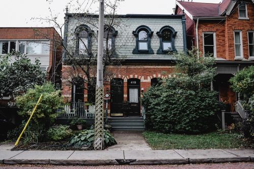 Free Charming Toronto townhouse with distinctive brick architecture surrounded by lush greenery. Stock Photo