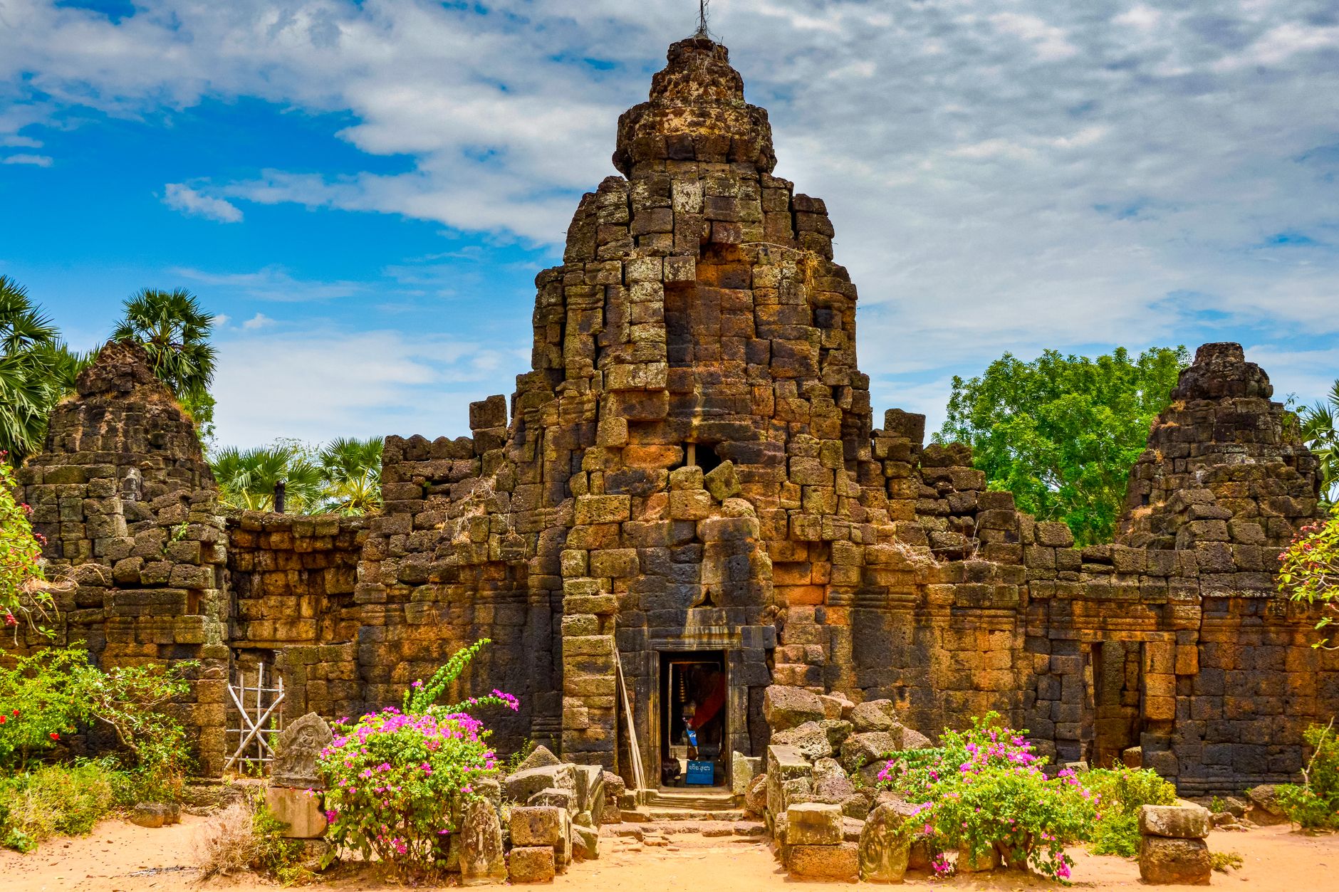 Explore the captivating ancient Khmer temple ruins with vibrant flora in Cambodia.