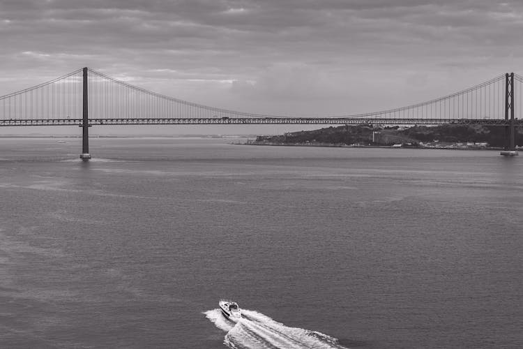 A Grayscale Photo Of The 25 De Abril Bridge