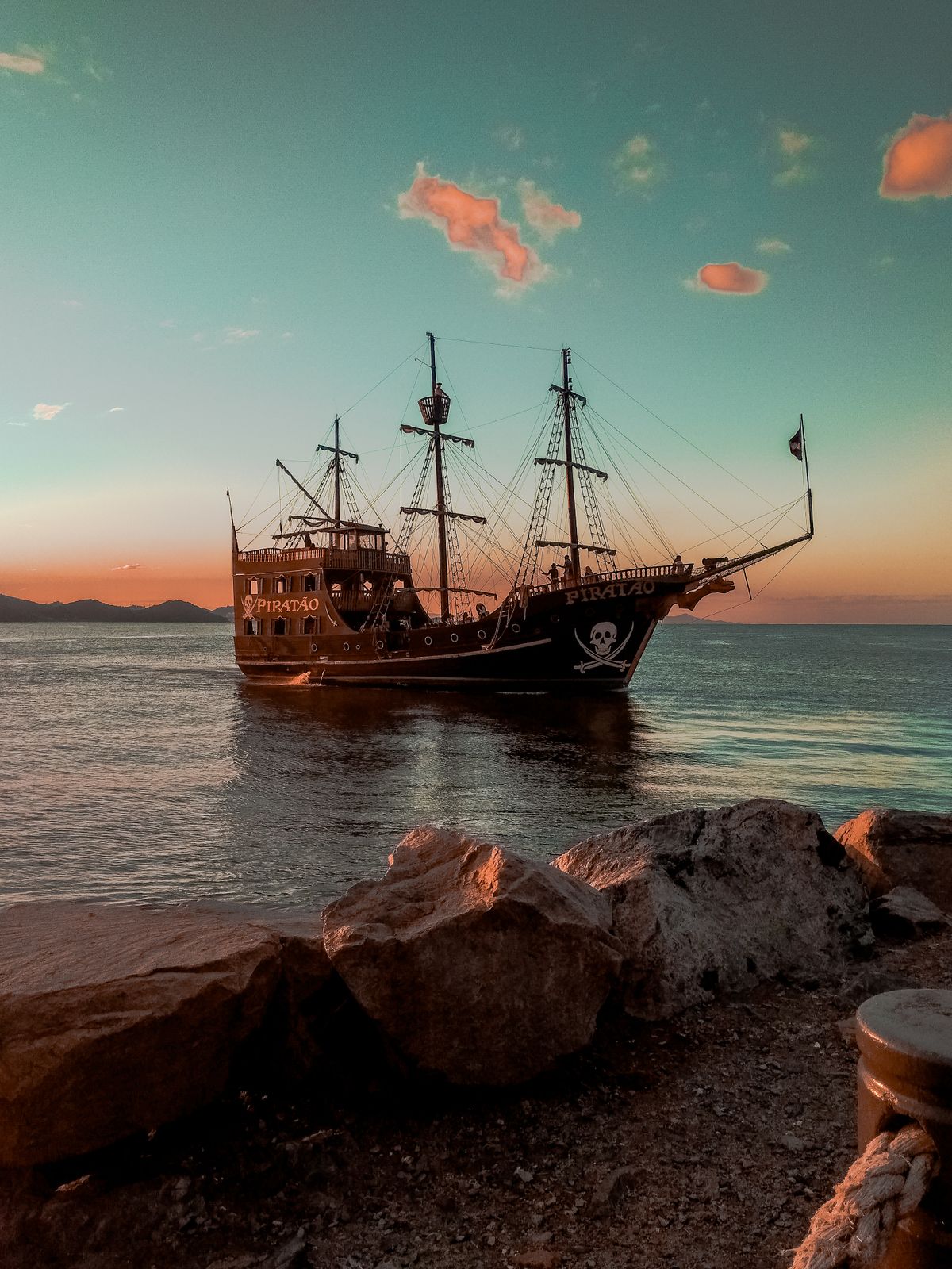 夕暮れの海に浮かぶ帆船のイメージ