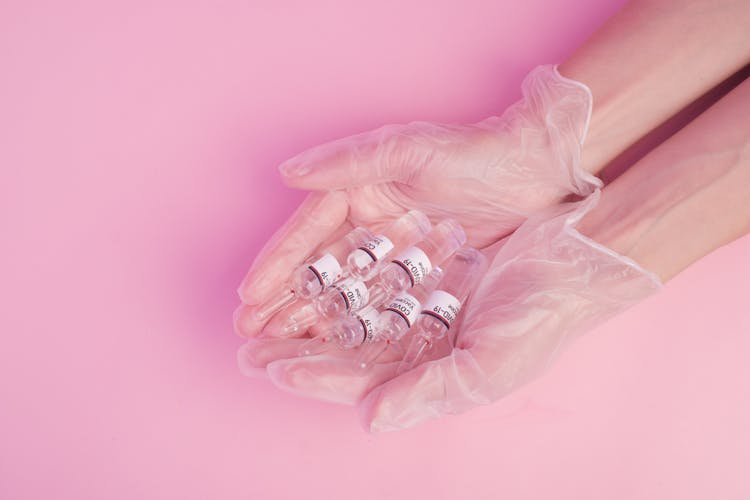 Anonymous Woman Demonstrating COVID 19 Vaccine Ampules In Hands