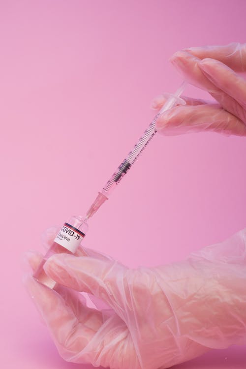 Anonymous doctor preparing injection of coronavirus vaccine