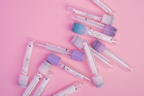 Free Set of blood test vials arranged on pink table Stock Photo