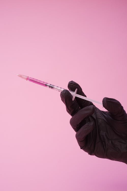 Anonymous doctor showing syringe with injection