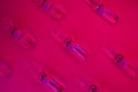 Set of ampules with virus vaccine on fuchsia background