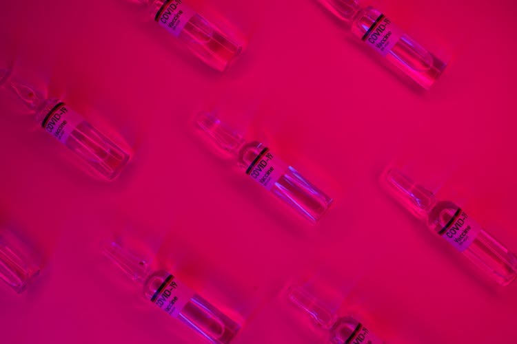 Set Of Ampules With Virus Vaccine On Fuchsia Background