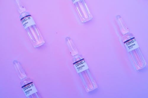 Ampoules containing pharmaceutical products on purple surface