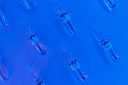 Free Coronavirus vaccine in similar sealed vial in blue lab Stock Photo