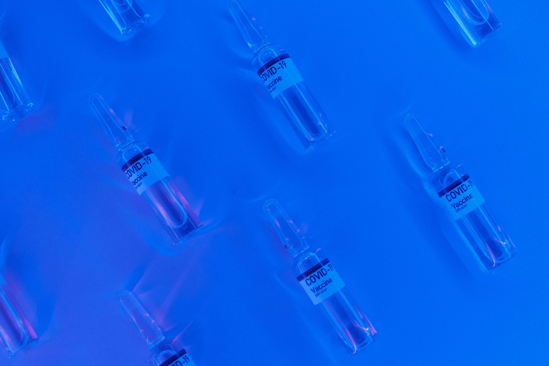 Coronavirus vaccine in similar sealed vial in blue lab