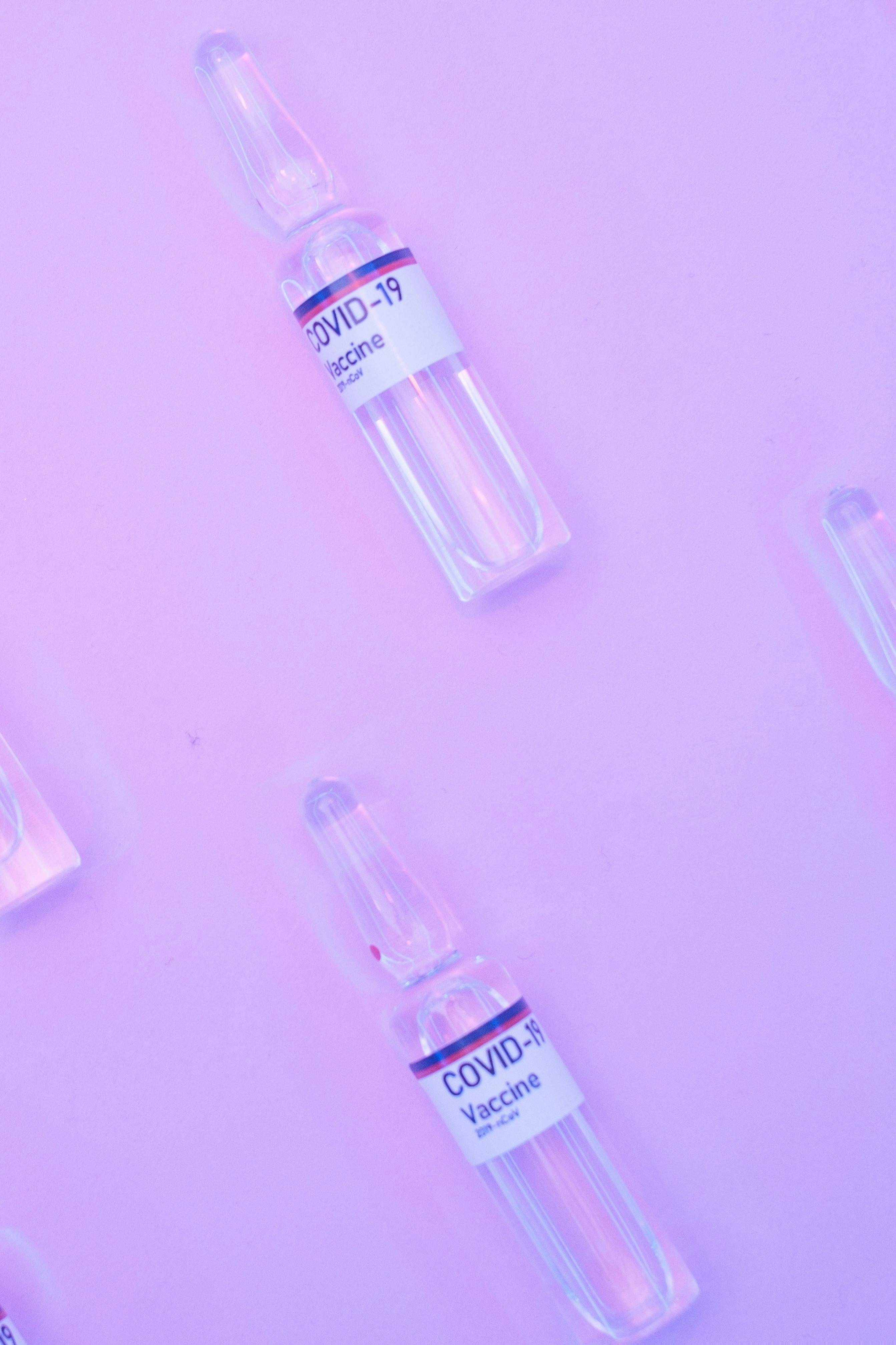 layout of ampoules of covid vaccine on purple surface