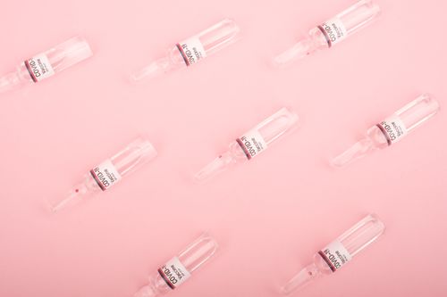 Free Top view set of COVID vaccines ampoules arranged on pink surface as abstract background Stock Photo