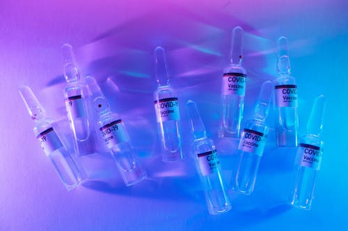 Free From above set of COVID 19 vaccines placed on table in modern laboratory with bright neon lights Stock Photo