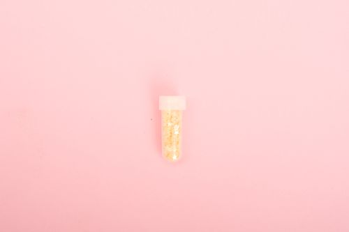 Free Top view of tube with tiny sparkling stars for decoration on pink background Stock Photo