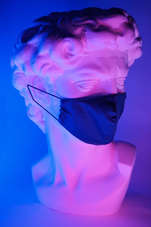 Free White plaster sculpture of Apollo in protective medical mask on neon blue background Stock Photo