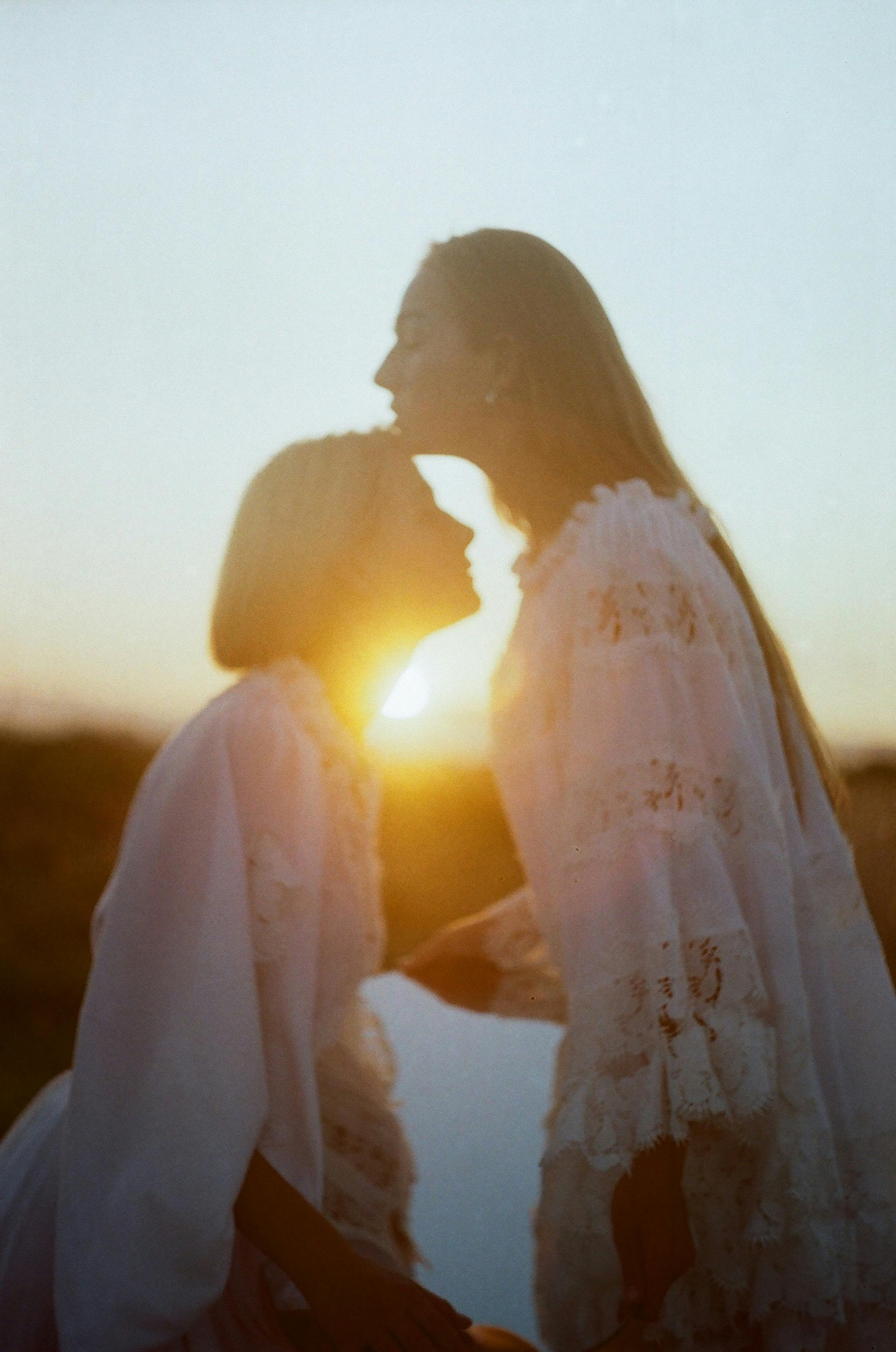 romantic lesbian couple caressing against sunshine in nature