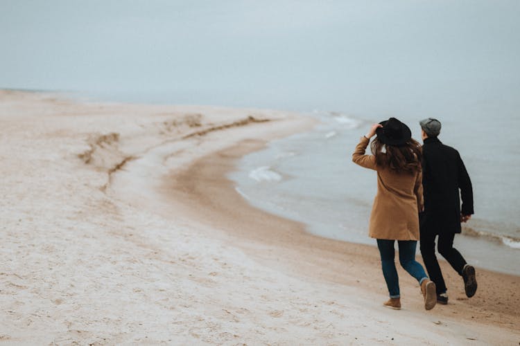 A Couple Running On A Beach