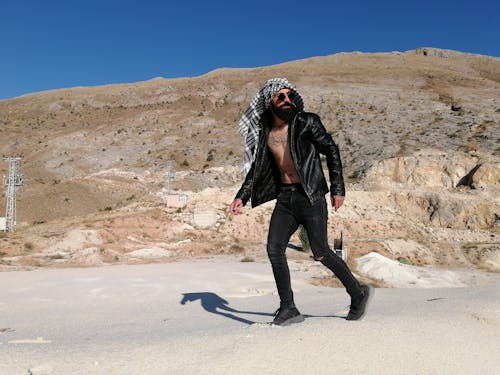 A Bearded Man Wearing a Black Leather Jacket and a Headscarf