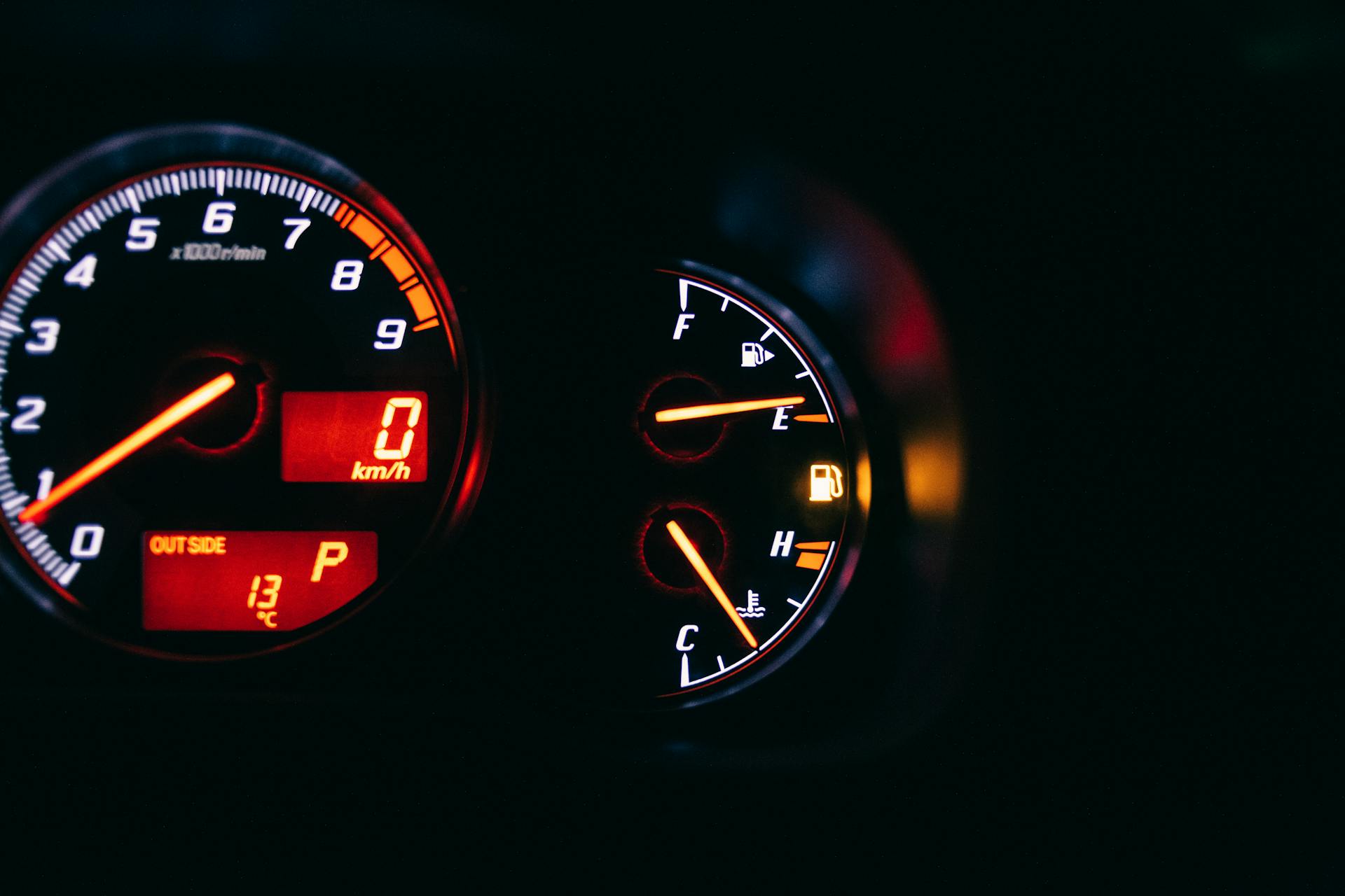 Modern control and measuring devices with arrows indicating numbers and letters on scales in automobile on black background