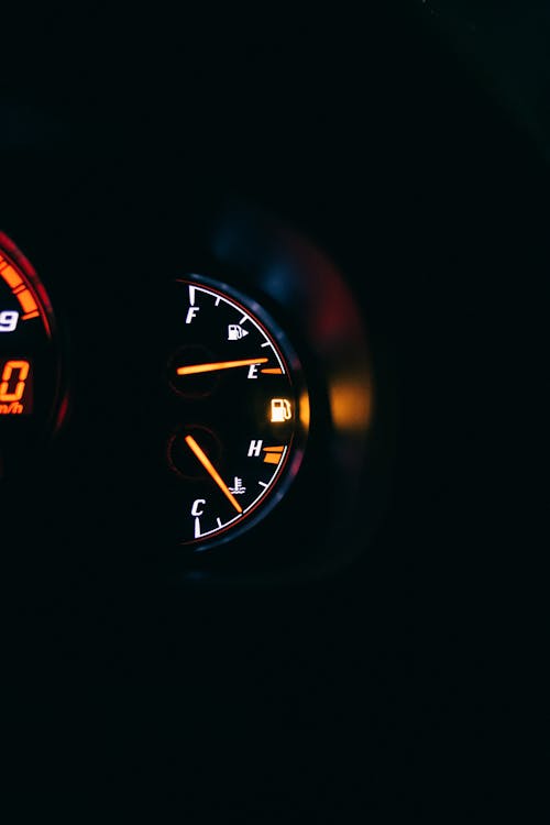 Free Control panel with fuel gauge representing arrows and scale with letters between gasoline station symbols in auto on black background Stock Photo