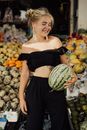 Woman in Black Tube Top and Black Skirt Holding Watermelon
