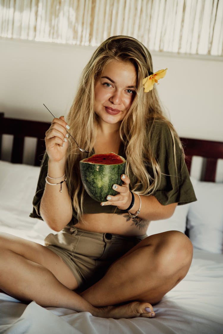 
A Woman Eating A Watermelon In Bed