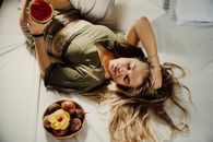 Woman in Brown Sleeveless Shirt Lying on Bed