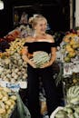 Woman in Black Off Shoulder Shirt and Black Pants Holding Green Vegetable