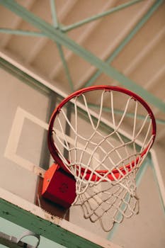 Detailed close-up of a basketball hoop with net in an indoor gym setting.