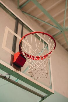 Detailed view of a basketball hoop and net in an indoor court setting.