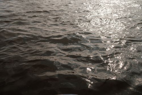 Free From above of clear sea with bright sun glares on water surface flowing in nature on evening time at sunset Stock Photo