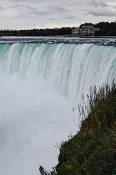 Breathtaking view of water cascading over Niagara Falls surrounded by nature, Ontario, Canada.