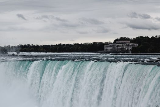 Majestic Niagara Falls captured on a cloudy day, showcasing powerful water flow and natural beauty.